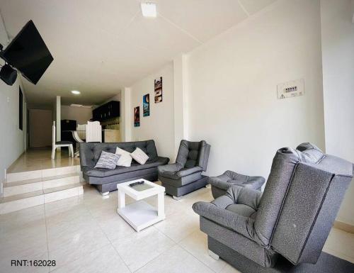 a living room with two couches and a tv at Rincón Familiar-en Corredor Turistico -SRC in Santa Rosa de Cabal