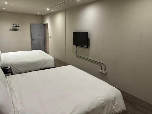 北港鎮的住宿－朝聖行旅，客房设有两张床和一台墙上的电视。