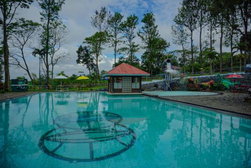 a swimming pool at a resort with a gazebo at Kebun Teh Wonosari Rollaas Hotel & Resort in Malang