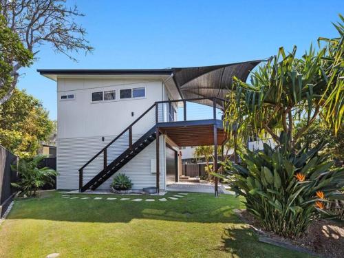 a house with a staircase in a yard at Casuarina Cove in Casuarina