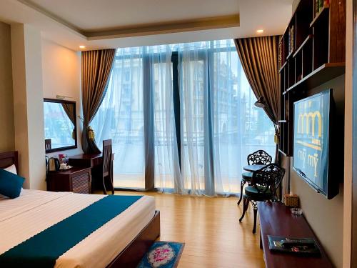 Dormitorio con cama, escritorio y TV en Hotel Mỹ Mỹ en Tây Ninh