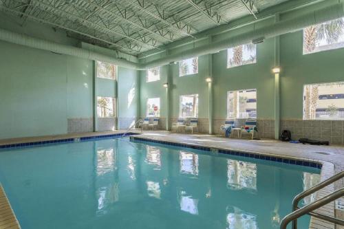 a large swimming pool with blue water in a building at Beachfront Spacious Renovated Condo - Pools, Hot Hub, Spa - Walk to Pier Park in PCB in Panama City Beach