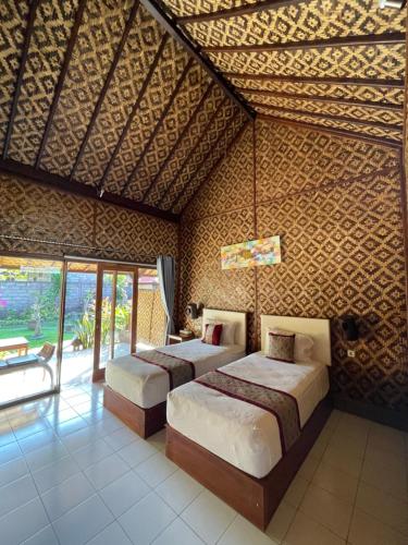 a bedroom with two beds in a room at Tebu menjangan homestay in Banyuwedang