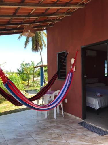 a room with a hammock and a bedroom at Chalé recanto do sol in Santo Amaro