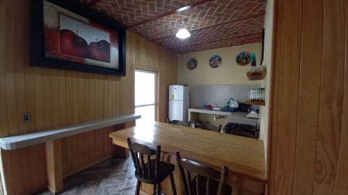Cabaña “De Aurora” في مازاميتلا: مطبخ مع طاولة وكراسي وثلاجة