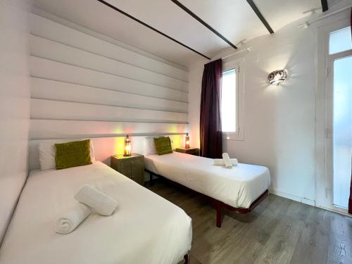 Habitación con 2 camas y ventana en Stay U-nique Apartments Fontrodona, en Barcelona