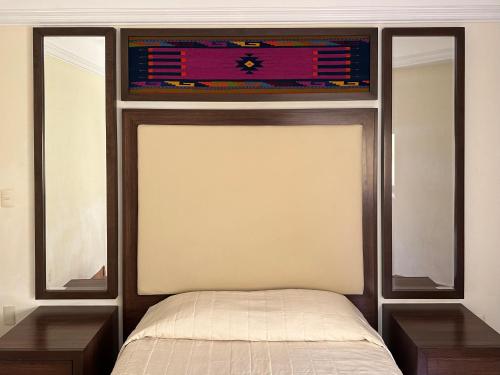 um quarto com uma cama com duas mesas e uma janela em Hostal Nordés em Oaxaca de Juárez