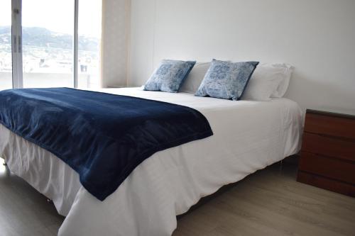 - une chambre avec un grand lit et des oreillers bleus dans l'établissement Apartamento lujoso junto al lago, à Paipa