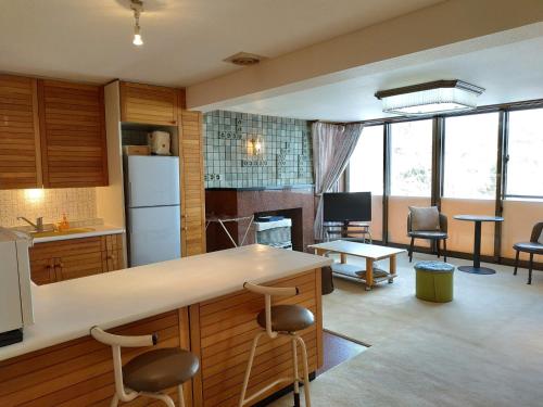 cocina y sala de estar con barra y sillas en Bay View House private room / Vacation STAY 3667, en Otaru