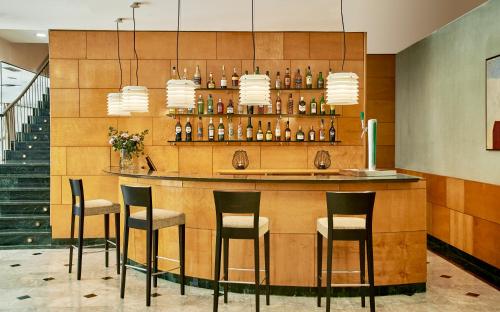 a bar in a hotel with chairs and bottles at NH Ciutat de Reus in Reus
