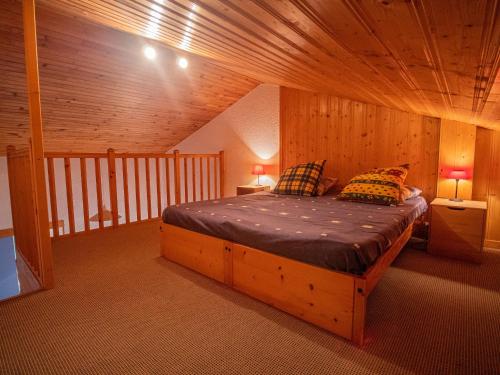 ヴァルモレルにあるAppartement Valmorel, 2 pièces, 4 personnes - FR-1-356-188の木製の部屋にベッド1台が備わるベッドルーム1室があります。
