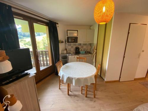 une cuisine avec une table et un chiffon de table blanc dans l'établissement Studio au calme avec balcon, parking couvert et kitchenette équipée! - FR-1-692-90, à Abondance