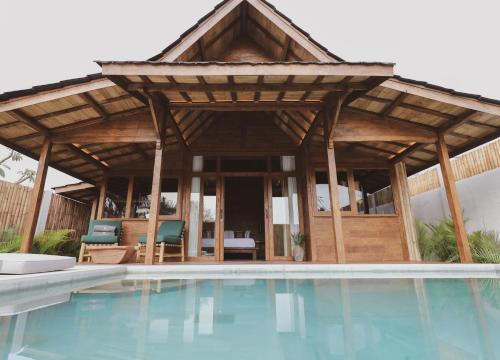 um pavilhão com piscina em frente a uma casa em Kalyana Villa Gili Air em Gili Air