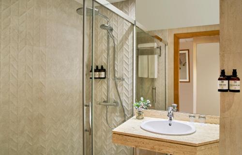 een badkamer met een wastafel en een douche bij NH Ciutat de Reus in Reus