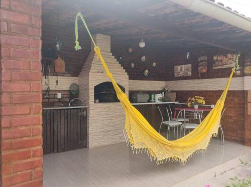 a yellow hammock on a patio in a kitchen at Seu paraíso em Maricá in Maricá