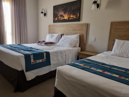 2 Betten in einem nebeneinander liegenden Hotelzimmer in der Unterkunft Quinta de Santa Bárbara Eco Resort Luxo Reveillon in Pirenópolis