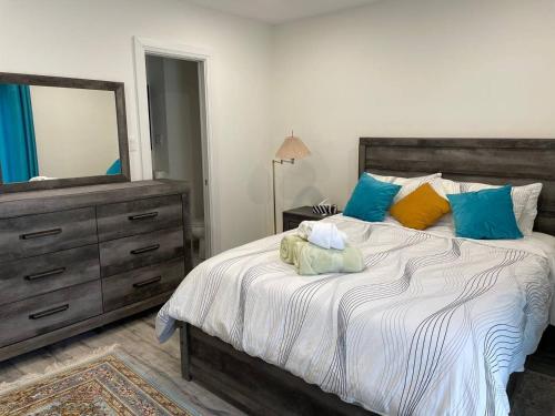 a bedroom with a bed with a dresser and a mirror at Mama Gol in Richmond Hill