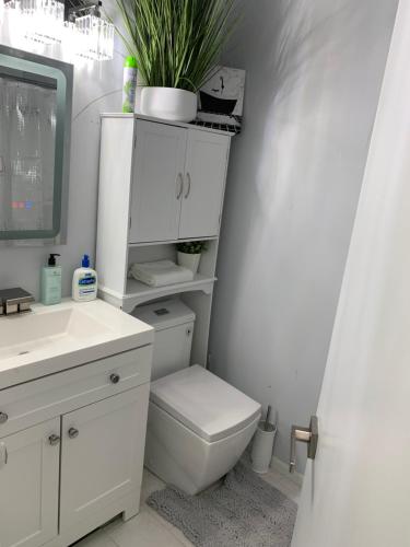 a white bathroom with a toilet and a sink at Little Paris Eiffel Tower Suite in Owings Mills