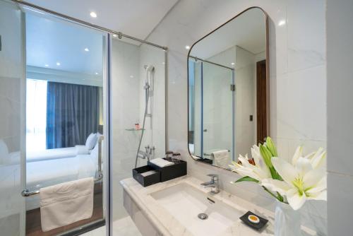 a bathroom with a sink and a mirror at Northern Charm Hotel in Ho Chi Minh City