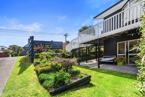 a house with a garden in front of it at Coastal Oasis - Papamoa Beach Holiday Home in Papamoa