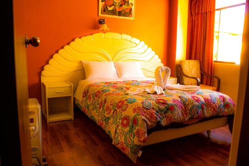 1 dormitorio con 1 cama grande y colcha colorida en ANDENES DEL TITICACA, en Puno