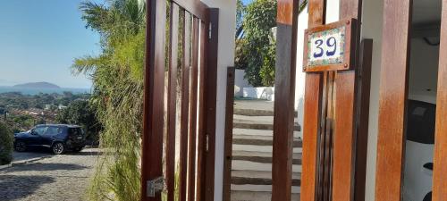 a gate to a house with a sign on it at 3Suítes, piscina e vista do mar em condomínio pé na areia - pátio compartilhado in Búzios