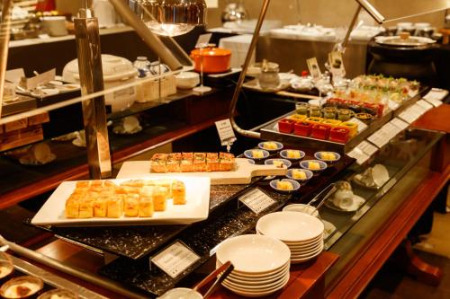 a buffet line with appetizers and desserts on plates at Kanazawa New Grand Hotel Premier in Kanazawa