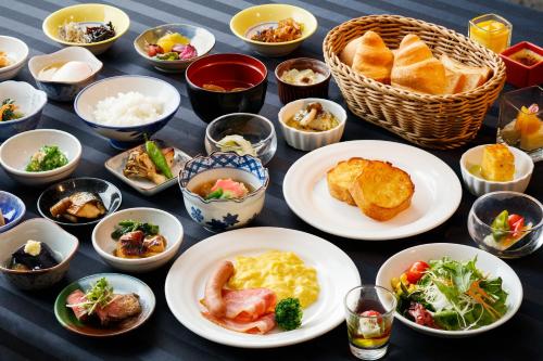 a table with plates of food and bowls of food at Kanazawa New Grand Hotel Premier in Kanazawa