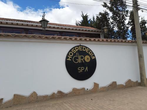 a sign on the side of a white wall at Hotel El Giro in Villa de Leyva