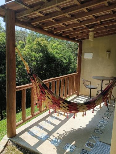 a hammock on the deck of a house at Recanto Berço das Aguas in Piraquara