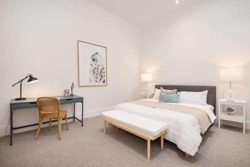 a bedroom with a bed and a desk and a chair at Character and Charm on Emerald Hill in Melbourne