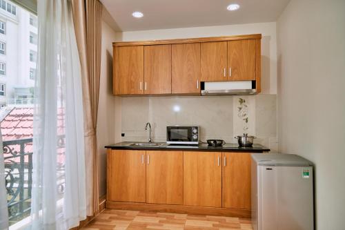 a small kitchen with wooden cabinets and a microwave at Air Star Hotel in Ho Chi Minh City