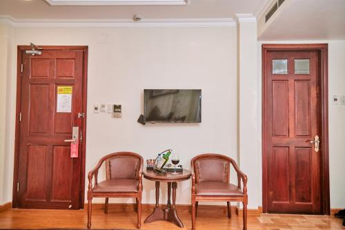 two chairs and a table in a room with a tv at Air Star Hotel in Ho Chi Minh City