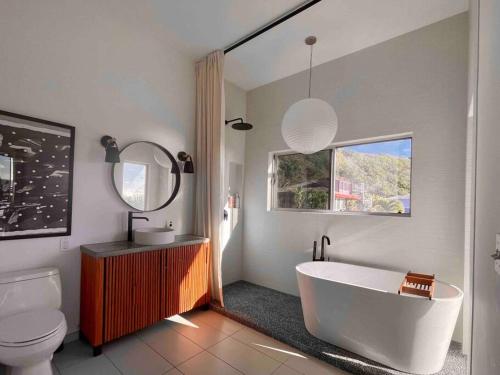 uma casa de banho com uma banheira, um WC e um lavatório. em Walk Minutes to beach/Ocean views/with AC/Waimea Bay em Haleiwa
