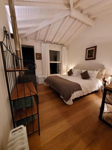 a bedroom with a large bed and a wooden floor at Pousada Boutique Itaipava in Itaipava