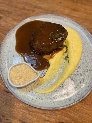 a plate of food with meat and sauce on a table at Pousada Boutique Itaipava in Itaipava