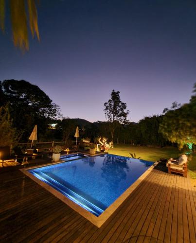 a swimming pool in a backyard at night at Pousada Boutique Itaipava in Itaipava