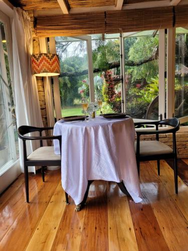 a table with a white table cloth on it in a room at Pousada Boutique Itaipava in Itaipava