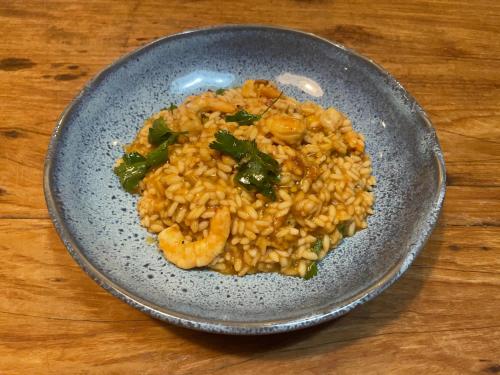 a plate of shrimp and rice on a wooden table at Pousada Boutique Itaipava in Itaipava