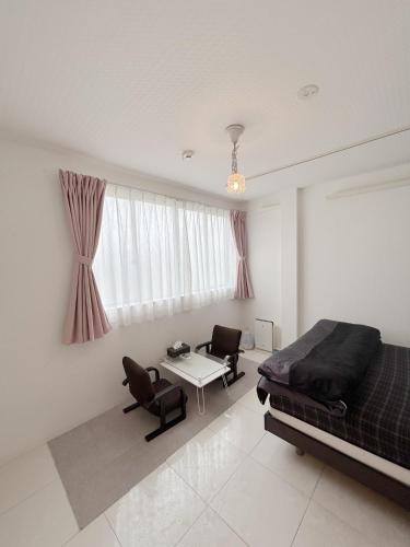 a bedroom with a bed and a table and chairs at 名古屋 Sakuraya 全屋抗菌涂层预防处理 6分钟直达名古屋车站 2间独立卫生间 2间独立淋浴房 4间卧室 in Nagoya