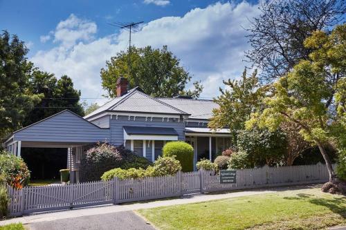 a blue house with a white fence at Inglenook Cottage Healesville in Healesville