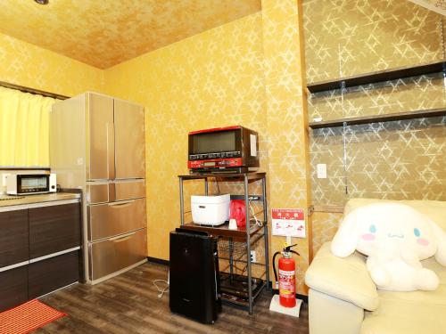 a kitchen with a couch and a microwave and a refrigerator at 名古屋 Sakuraya 全屋抗菌涂层预防处理 6分钟直达名古屋车站 2间独立卫生间 2间独立淋浴房 4间卧室 in Nagoya