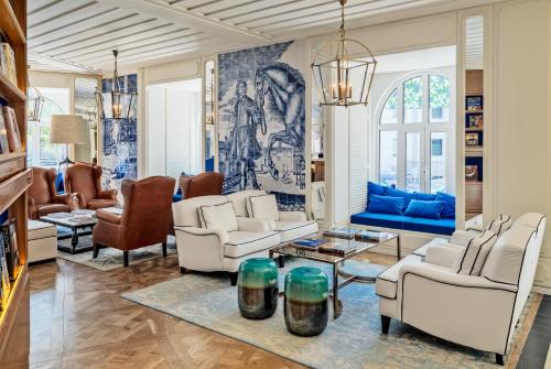 a living room with white furniture and blue walls at H10 Duque de Loule in Lisbon
