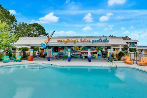 a pool at a resort with a restaurant at Hotel McCoy - Art, Libations, Pool Society in College Station