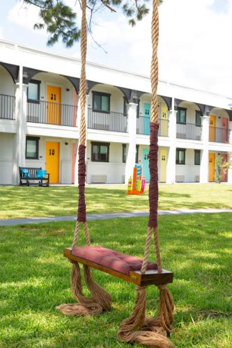 a swing in the grass in front of a building at Hotel McCoy - Art, Libations, Pool Society in College Station