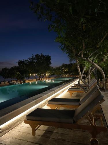 - un banc près de la piscine la nuit dans l'établissement SABAI Beach, à Barú