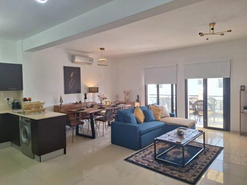a living room with a blue couch and a table at Paramount Gardens Resorts D204 in Tersephanou