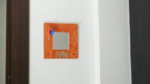 a picture of a wooden frame on a white wall at Apartment Studio Loft Ekaterina in Tbilisi City