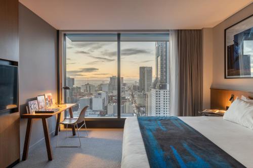 a hotel room with a bed and a desk and a window at The Adnate Perth - Art Series in Perth