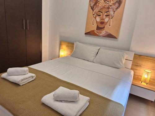 1 dormitorio con 1 cama blanca grande y toallas. en Paramount Gardens Resorts D204, en Tersephanou